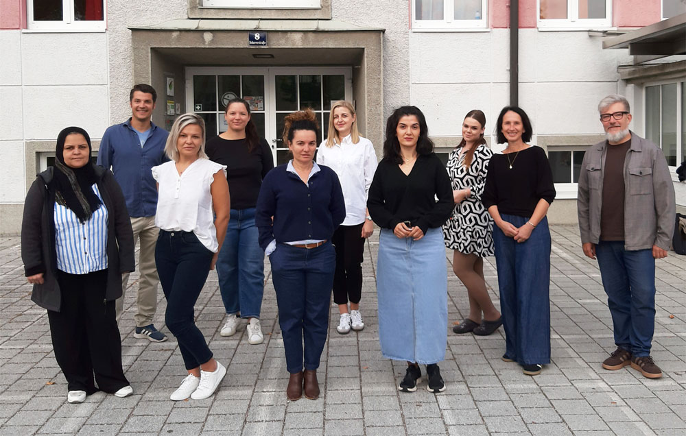 Sprach- und Kulturbegleiterinnen mit Schulleitungen und Koordinator, v. l: Mariam Alhossin, Tom Hutchison (Schulleiter), Mirzeta Mesic, Iulia Ardean, Valbona Lamanjaku, Marina Klaric, Yara Hami, Ajla Alispahic, Regina Hemetsberger (Schulleiterin), Christoph Hatheier (Projektkoordinator)